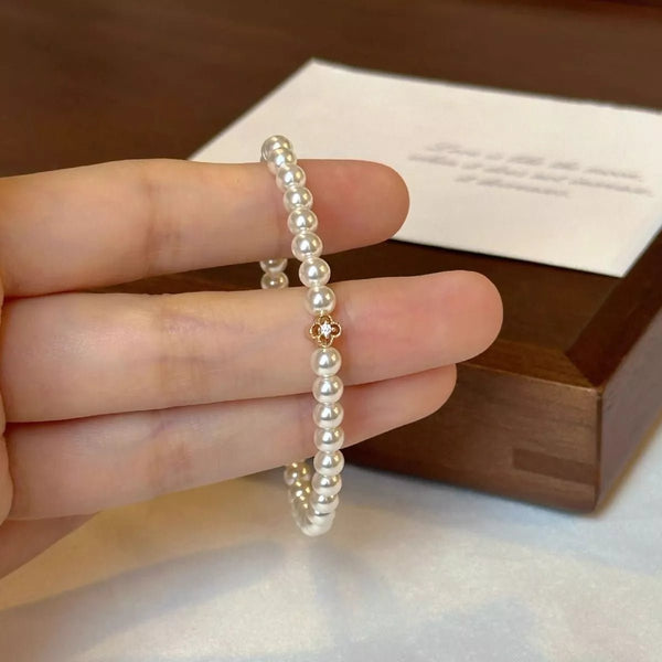 Gold floral pearl bracelet with delicate crystal accents and feminine detailing.