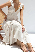 Ivory tiered cotton maxi dress with ruffled shoulders and flowing romantic silhouette.