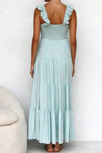 Ivory tiered cotton maxi dress with ruffled shoulders and flowing romantic silhouette.