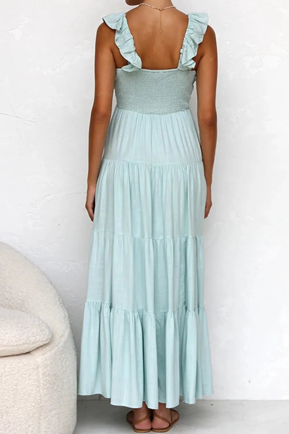 Ivory tiered cotton maxi dress with ruffled shoulders and flowing romantic silhouette.