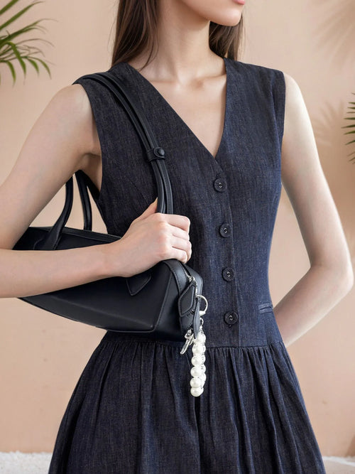 Elegant sleeveless navy midi dress with V-neckline and button-front detailing.