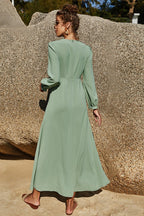Soft sage floral maxi dress with puff sleeves and flowing skirt styled outdoors.