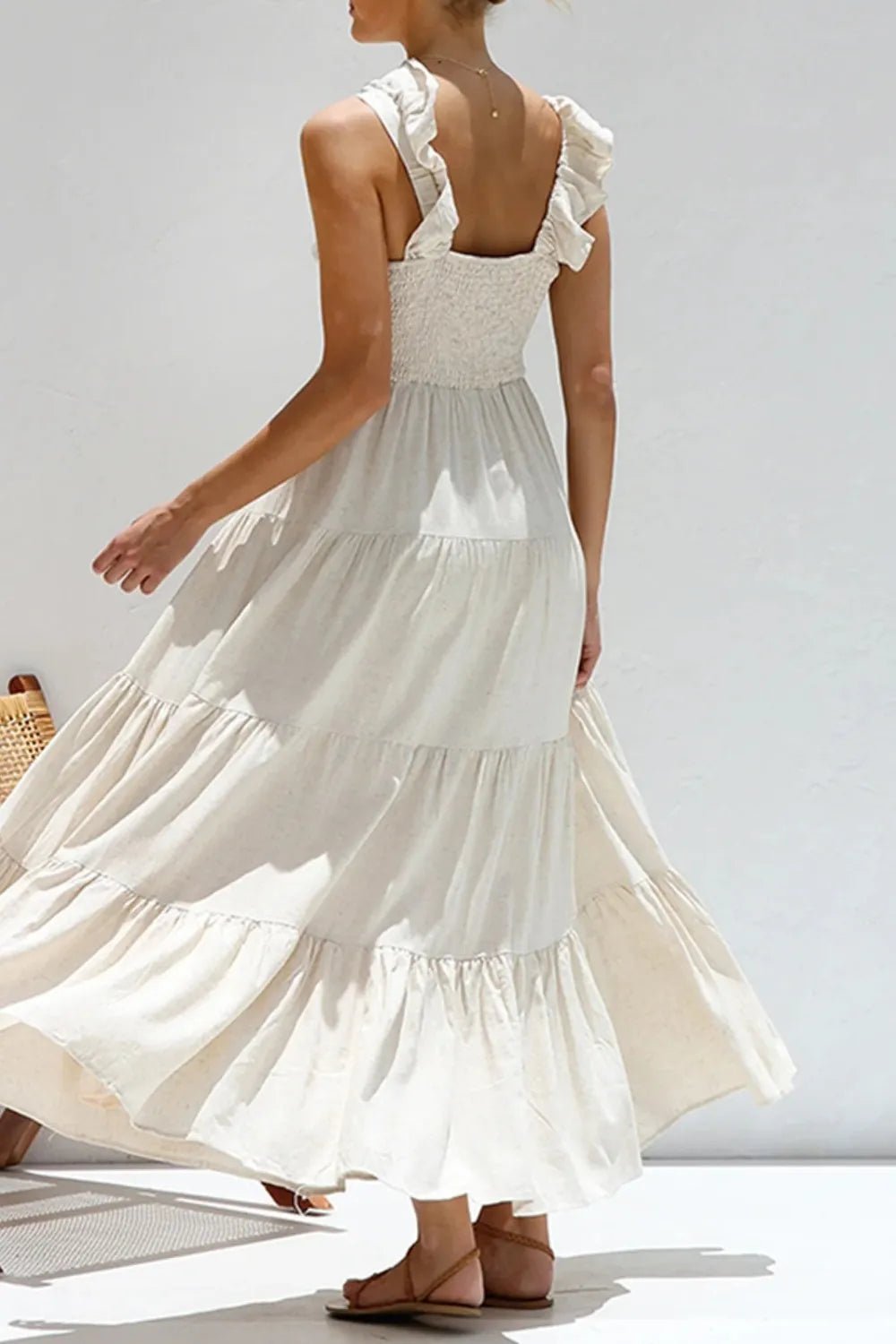 Ivory tiered cotton maxi dress with ruffled shoulders and flowing romantic silhouette.