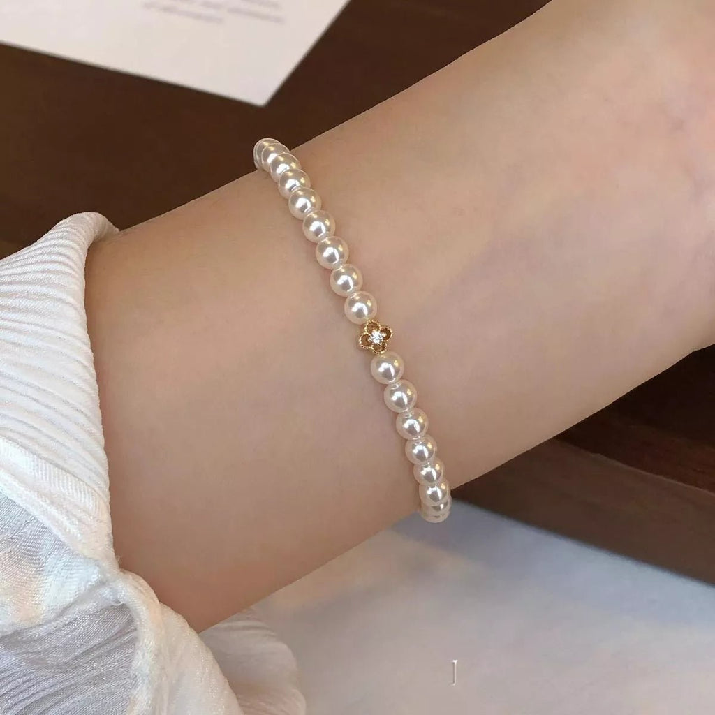 Gold floral pearl bracelet with delicate crystal accents and feminine detailing.
