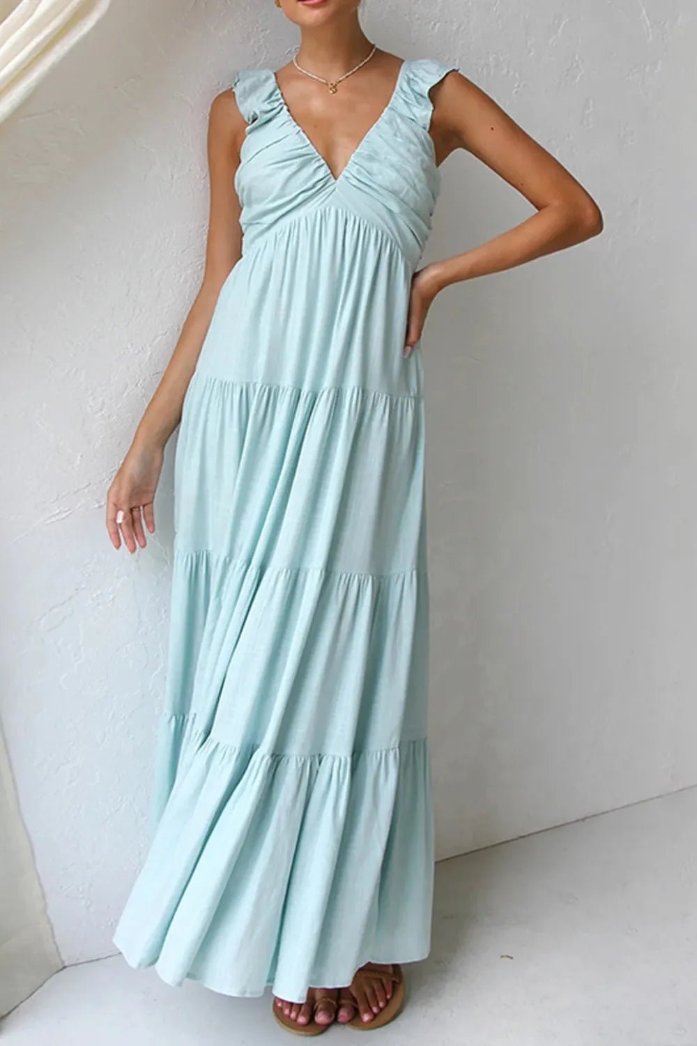 Ivory tiered cotton maxi dress with ruffled shoulders and flowing romantic silhouette.