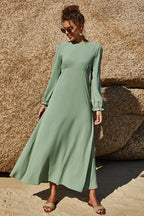Soft sage floral maxi dress with puff sleeves and flowing skirt styled outdoors.