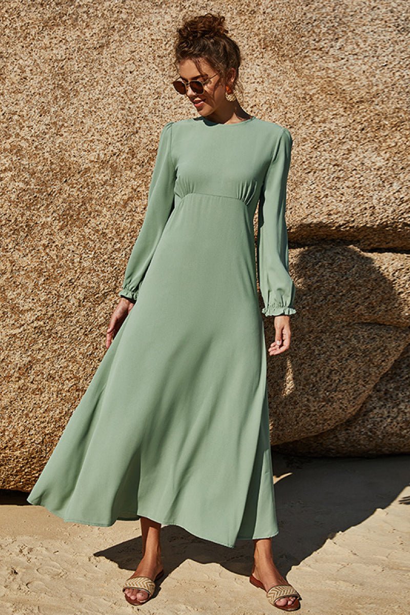 Soft sage floral maxi dress with puff sleeves and flowing skirt styled outdoors.