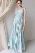Ivory tiered cotton maxi dress with ruffled shoulders and flowing romantic silhouette.