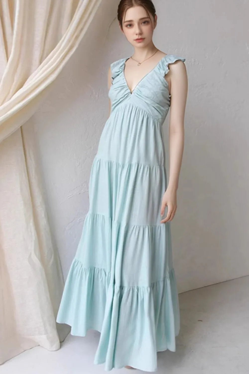 Ivory tiered cotton maxi dress with ruffled shoulders and flowing romantic silhouette.