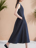 Elegant sleeveless navy midi dress with V-neckline and button-front detailing.