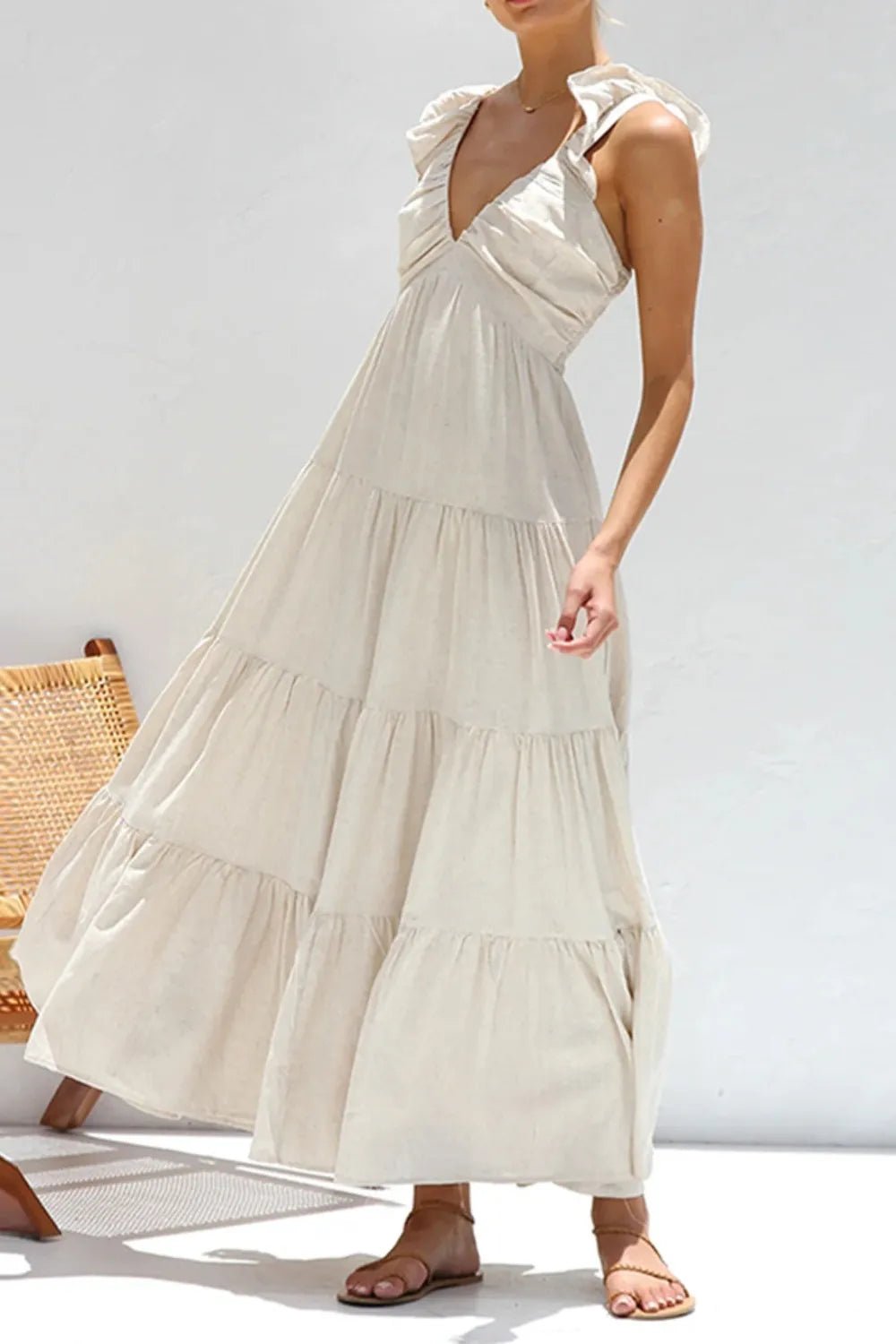 Ivory tiered cotton maxi dress with ruffled shoulders and flowing romantic silhouette.