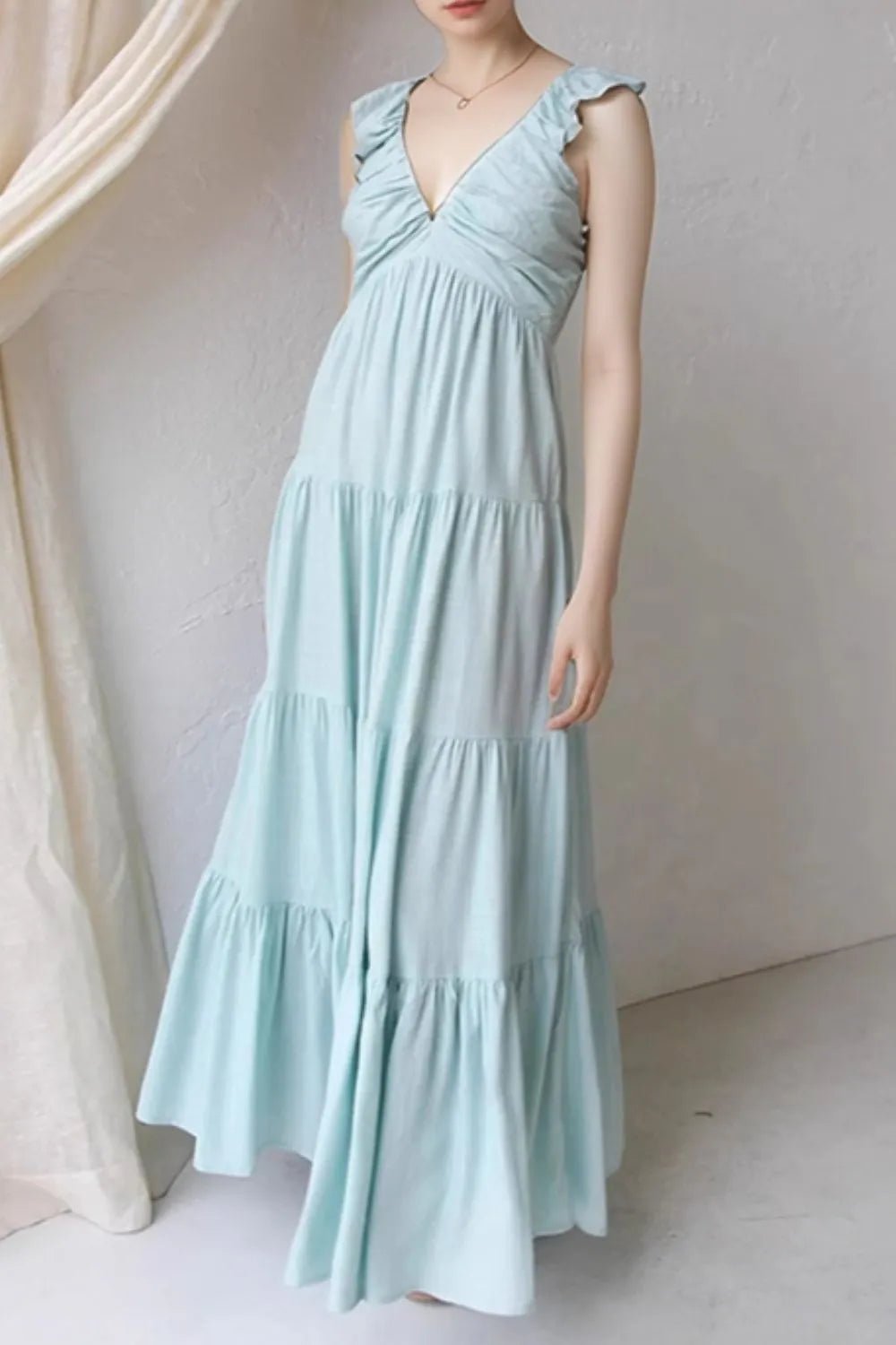 Ivory tiered cotton maxi dress with ruffled shoulders and flowing romantic silhouette.