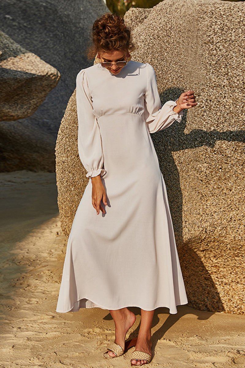 Soft sage floral maxi dress with puff sleeves and flowing skirt styled outdoors.