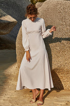 Soft sage floral maxi dress with puff sleeves and flowing skirt styled outdoors.