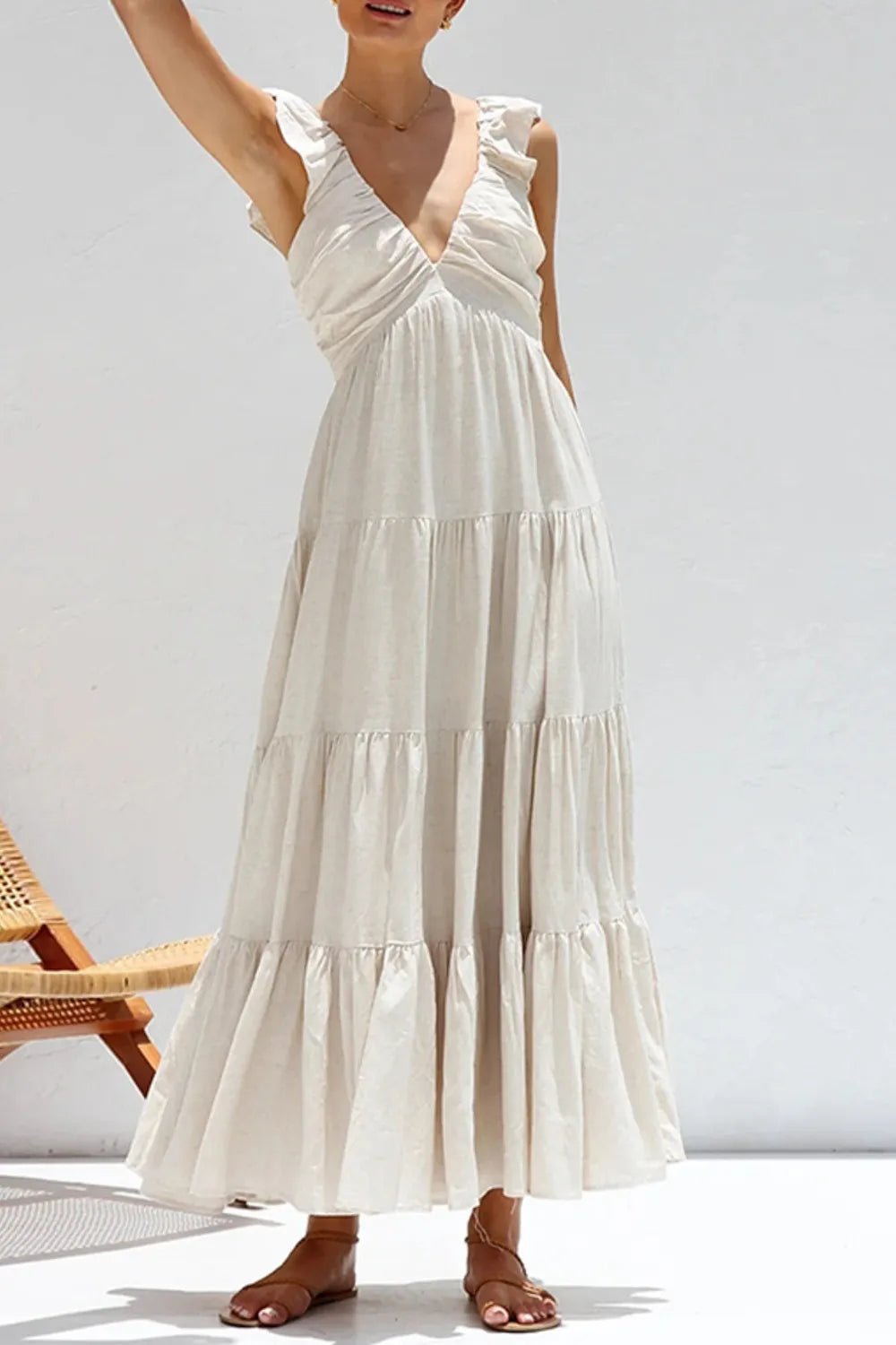 Ivory tiered cotton maxi dress with ruffled shoulders and flowing romantic silhouette.