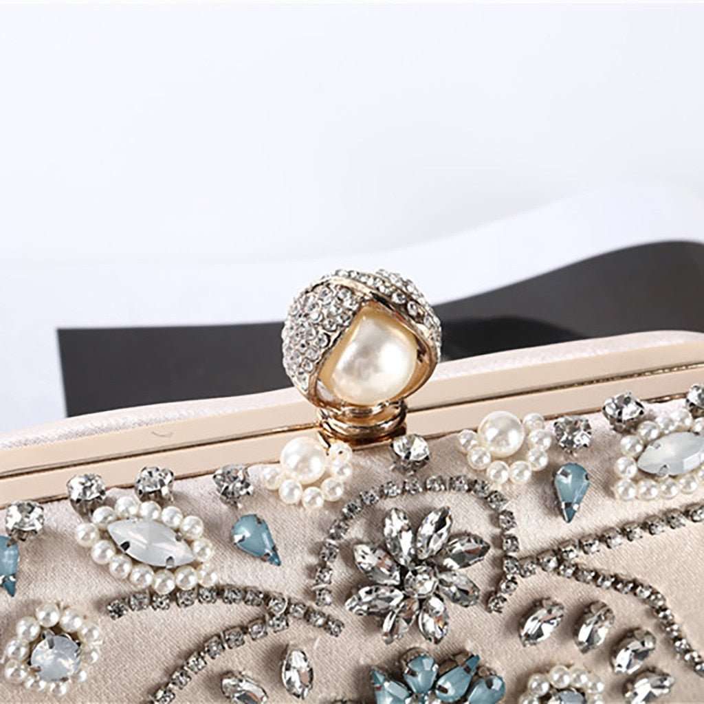 Designer metal clutch bridal chain bag in elegant gold finish with structured silhouette, polished metallic surface, and detachable chain strap, perfect for weddings, evening parties, and formal occasions.