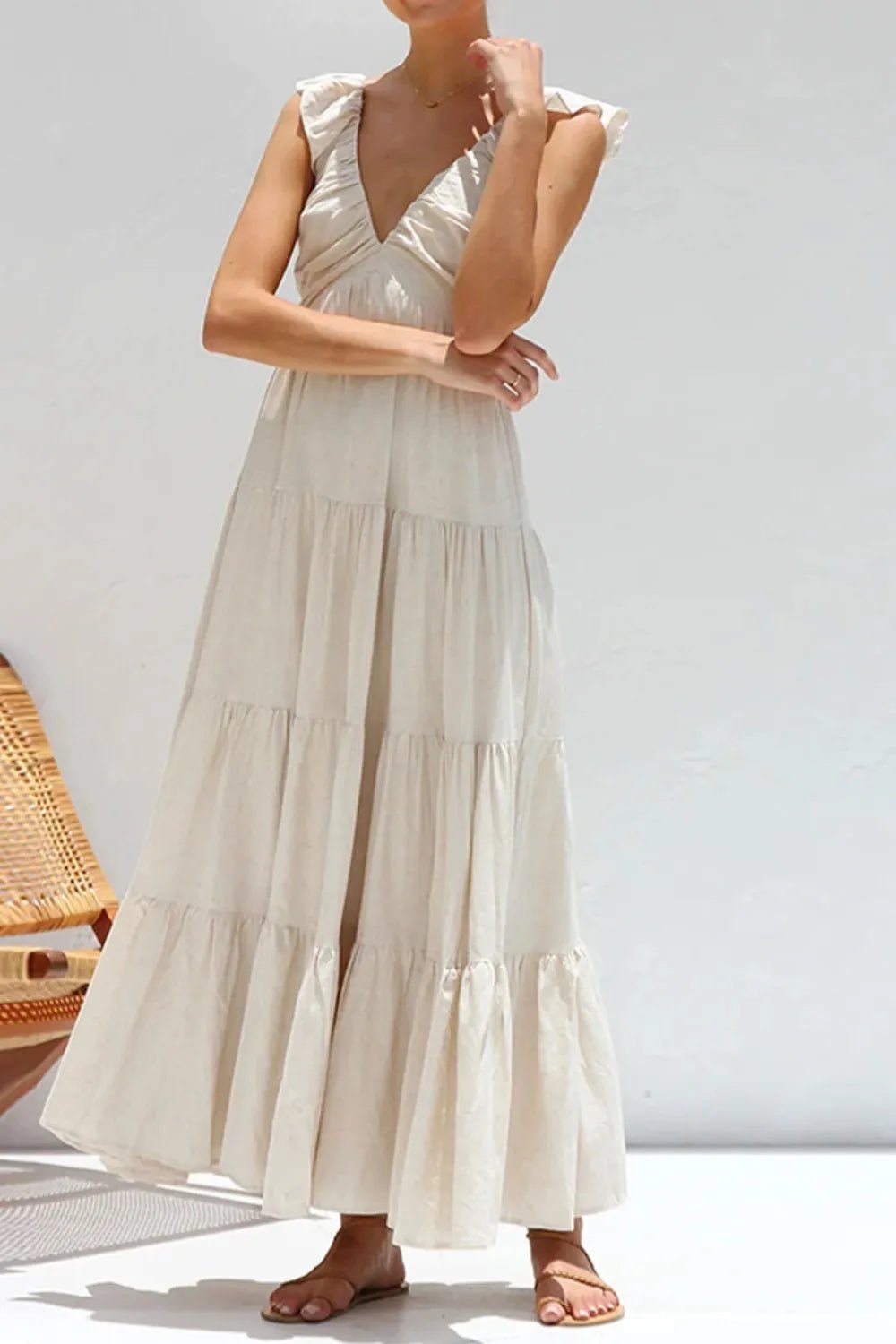 Ivory tiered cotton maxi dress with ruffled shoulders and flowing romantic silhouette.