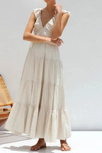 Ivory tiered cotton maxi dress with ruffled shoulders and flowing romantic silhouette.