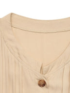 Elegant beige button-front maxi dress with long sleeves and flowing silhouette.