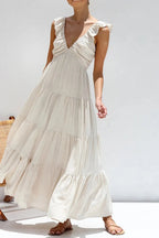Ivory tiered cotton maxi dress with ruffled shoulders and flowing romantic silhouette.
