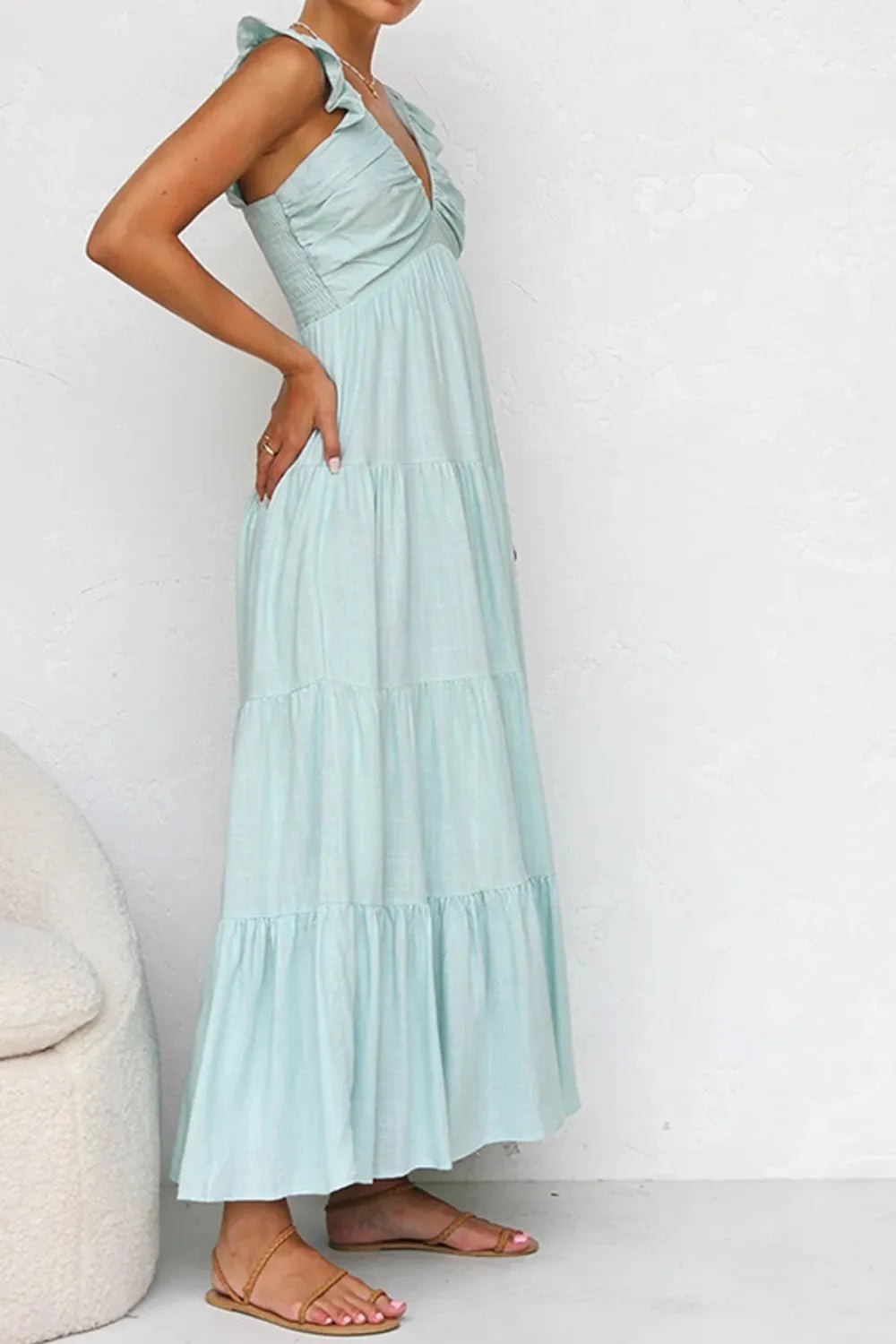Ivory tiered cotton maxi dress with ruffled shoulders and flowing romantic silhouette.