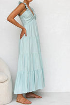 Ivory tiered cotton maxi dress with ruffled shoulders and flowing romantic silhouette.