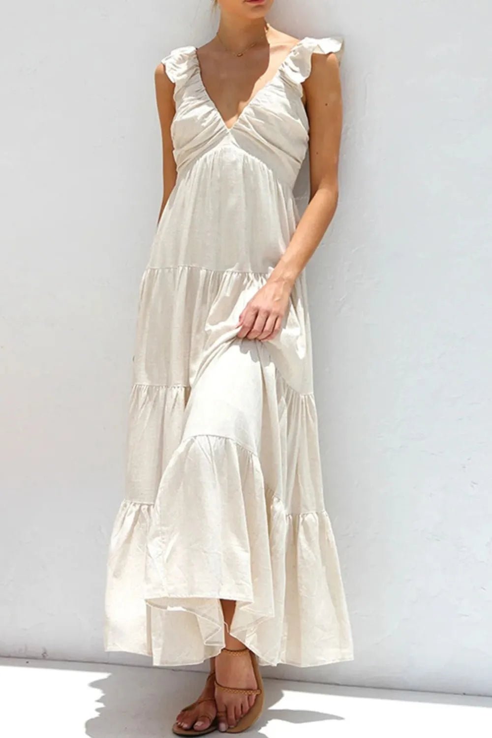 Ivory tiered cotton maxi dress with ruffled shoulders and flowing romantic silhouette.