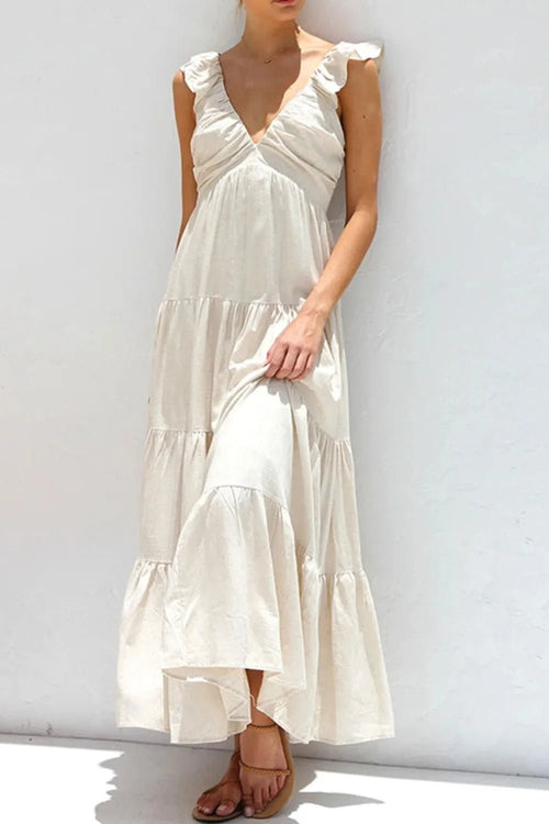 Ivory tiered cotton maxi dress with ruffled shoulders and flowing romantic silhouette.